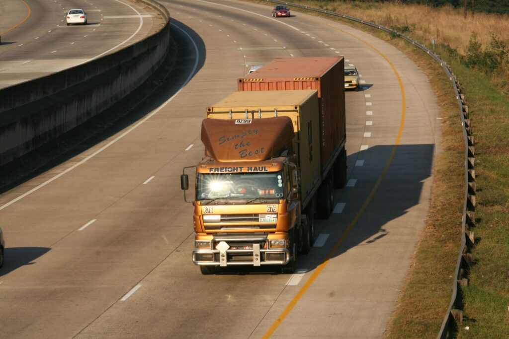 yellow truck on highway with loaded freight